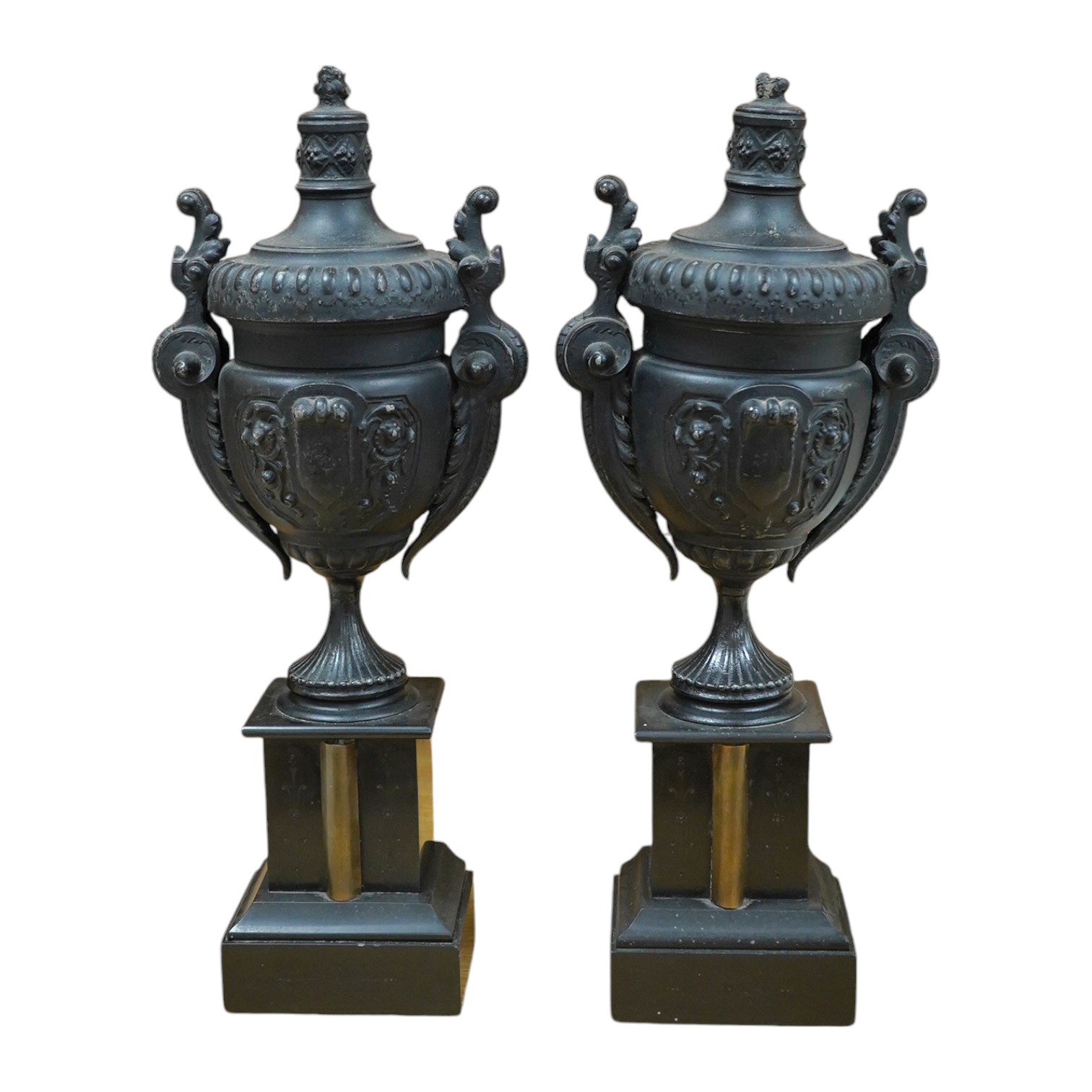 A pair of Victorian black metal and marble mantel clock garnitures, 45cm high. Condition - good